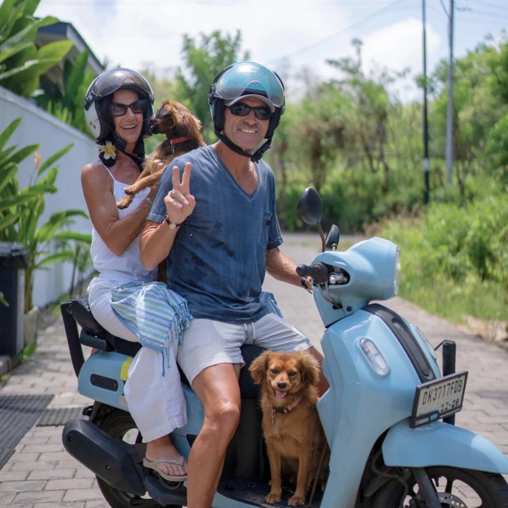 Retired couple on a scooter with their dogs